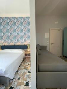 a hotel room with a bed and a couch at Guerrini Hotel in Castiglioncello