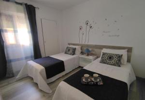 sypialnia z 2 łóżkami i tacą z jedzeniem w obiekcie ApartaSol w mieście Puerto de Santiago