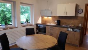 a kitchen with a wooden table and a table and chairs at Landhaus Bukenberger in Freudenstadt