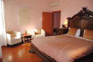 - une chambre avec un grand lit et deux chaises dans l'établissement Leon Bianco, à San Gimignano