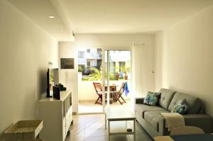 a living room with a couch and a table at Corralejo Sun 103 wifi free in Corralejo