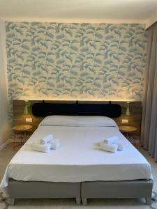 a bedroom with a bed with two towels on it at Guerrini Hotel in Castiglioncello
