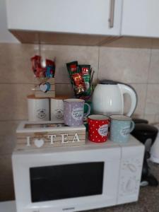 un microondas con m tazas encima en Apartman Miletic, en Mostar 40 fotos más