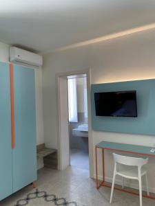 a room with a table and a tv on a wall at Guerrini Hotel in Castiglioncello