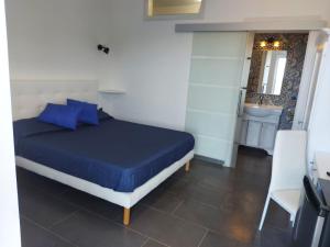 a bedroom with a bed with blue pillows and a bathroom at Casa del Sole in Ceraso