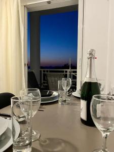 a bottle of wine sitting on a table with glasses at Sunset View Apartment, in the nature, at Zipari "6" in Kos