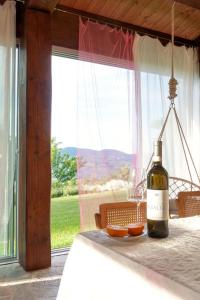 una botella de vino sentada en una mesa frente a una ventana en Agriturismo "Le Cannelle" spa & day wellness, en Fossombrone