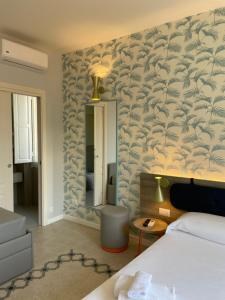 a hotel room with a bed and a mirror at Guerrini Hotel in Castiglioncello
