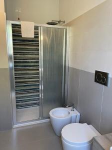 a bathroom with a shower and a toilet and a sink at Guerrini Hotel in Castiglioncello