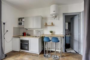 ベルサイユにあるLe Mousquetaireのキッチン(白いキャビネット、青いスツール付) +4枚の写真