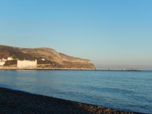 a view of the ocean with a rocky beach at The Oasis in Llandudno