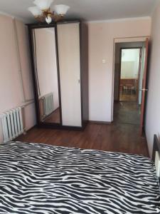 Un dormitorio con una cama en blanco y negro y un espejo en Комфортная квартира для гостей города, en Kyzylorda