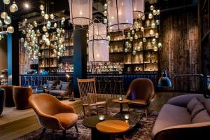 um bar com cadeiras e mesas num quarto em Motel One Hamburg-Fleetinsel em Hamburgo