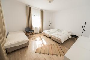- une chambre avec 3 lits, une chaise et une fenêtre dans l'établissement Casa Botár Vendégház, à Rimetea
