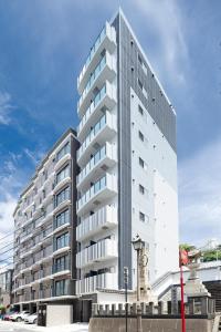 a tall building with a clock in front of it at Coruscant Hotel NagasakiekiⅢ in Nagasaki