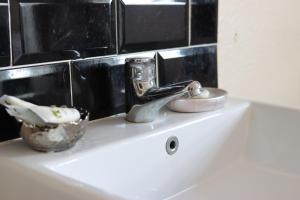 a white sink sitting under a mirror in a bathroom at Huntsman Tavern in Salisbury