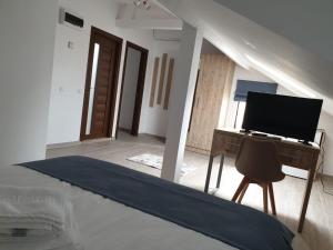 a bedroom with a bed and a desk with a computer at Pensiunea Lotus Corbu in Corbu