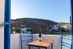 a table with a bottle of wine on a balcony at Meltemi Hotel Kythnos in Loutra