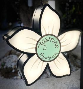 a black and white flower with a sign that reads asymptomatic at jasmine apartments in Eretria