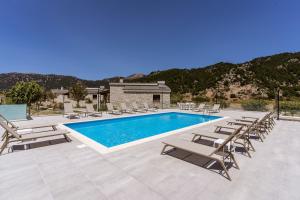 a swimming pool with chaise lounge chairs and a resort at Omalos Village in Omalos