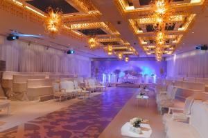 a banquet hall with white chairs and tables and chandeliers at Holiday Inn Kuwait by IHG in Kuwait +287 photos