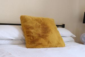 ソールズベリーにあるHuntsman Tavernの大きな黄色の枕(ベッドの上に座る)