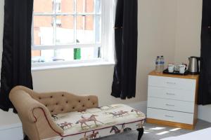 a bedroom with a chair and a dresser and a window at Huntsman Tavern in Salisbury