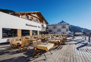 a row of tables and chairs in front of a building at Hotel Steffisalp - Ski-in & Ski-out am Arlberg in Warth am Arlberg