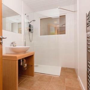 Un baño blanco con lavabo y ducha. en Shamerbrea The Foodie B&B, en Inverness