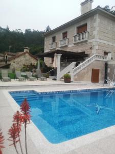 a large swimming pool in front of a house at casa salvante in Moaña