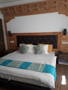 1 dormitorio con 1 cama grande y cabecero grande en Hotel Royal Plaza, en Leh