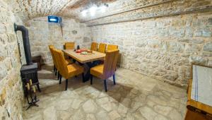 a dining room with a table and chairs and a fireplace at Villa Rosa in Ravno