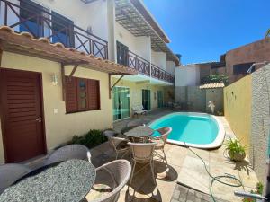 a patio with a table and chairs and a swimming pool at Pousada Dunas Beach in Canoa Quebrada