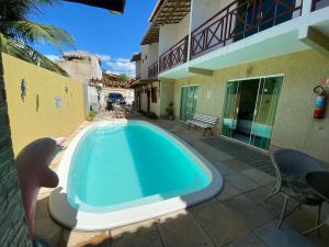 a swimming pool in front of a house at Pousada Dunas Beach in Canoa Quebrada