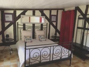 a bedroom with a black and white bed with pillows at Maison charmante à Souvigny-en-Sologne avec jardin in Souvigny-en-Sologne