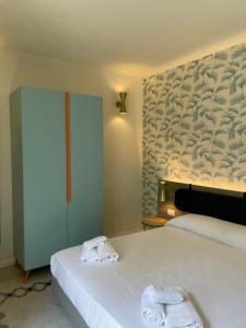 a bedroom with two white towels on a bed at Guerrini Hotel in Castiglioncello