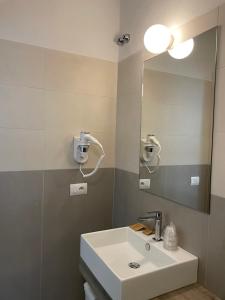 a bathroom with a sink and a mirror at Guerrini Hotel in Castiglioncello