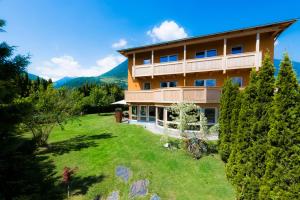 a large building with a lawn in front of it at Residence-Garni Haus Tschenett in Prato allo Stelvio
