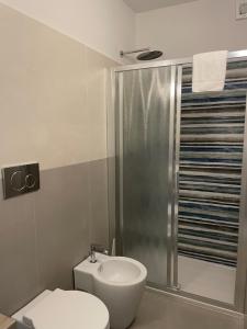 a bathroom with a shower and a toilet and a sink at Guerrini Hotel in Castiglioncello