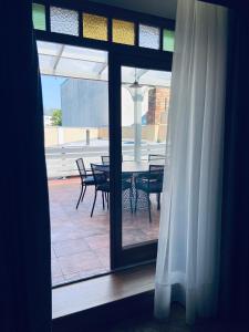 a view of a patio with a table and chairs through a window at Roze Republikas Apartments in Liepāja