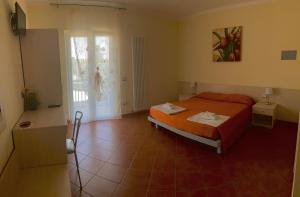 a bedroom with a orange bed and a window at Il Nido Delle Rondini in Grottole