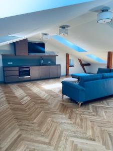 a living room with a blue couch and wooden floors at Roze Republikas Apartments in Liepāja