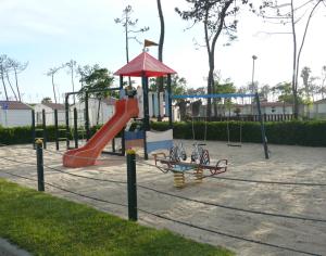 a playground with a slide in a park at Parque De Campismo Orbitur Gala in Figueira da Foz