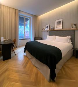 a bedroom with a large bed with a black blanket at Hôtel National Des Arts et Métiers in Paris