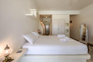 sypialnia z dużym białym łóżkiem w pokoju w obiekcie Blu Suites and Studios w mieście Adamas