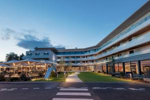 a building with tables and umbrellas in front of it at Rivage Hôtel & Spa Annecy in Annecy