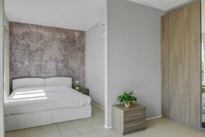 1 dormitorio con cama blanca y armario de madera en MyPlace Padova Ospedale en Padua