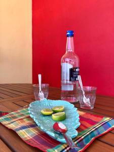 un piatto con sottaceti su un tavolo con una bottiglia d'acqua di Zandoli Cottage a Les Galets