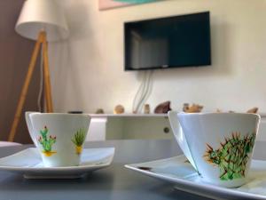 two cups sitting on plates on a table at Zandoli Cottage in Les Galets