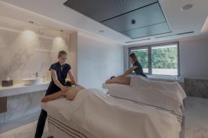two women sitting on beds in a room at Rivage Hôtel & Spa Annecy in Annecy